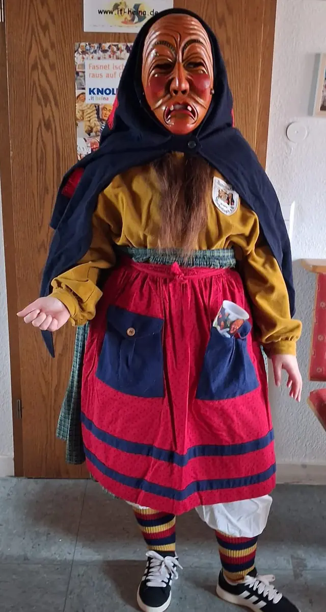 Schrättele mit offenen Haaren, ohne Handschuhe, mit sichtbarem Becher, Hexenhose und Turnschuhen